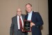 Dr. Nagib Callaos, General Chair, giving Dr. R. Cherinka a plaque for Mr. J. Wahnish  in appreciation for co-presenting a Plenary Keynote Address, titled "Fostering Partnerships between Industry and Academia to promote Science, Technology, Engineering and Mathematics Education."